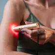 Hånd der holder en guldfarvet Heat Sense-pen mod indersiden af en arm, hvor rødt lys skinner